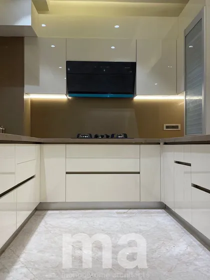A straight-on view of the main kitchen workspace. The handleless design of the drawers and cabinets contributes to the clean, uncluttered, and sophisticated aesthetic.