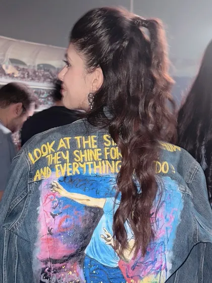 A shot from the back at the Coldplay concert, showing how the half-up hairstyle looks in a real-world event setting. The style is secure yet has natural movement.