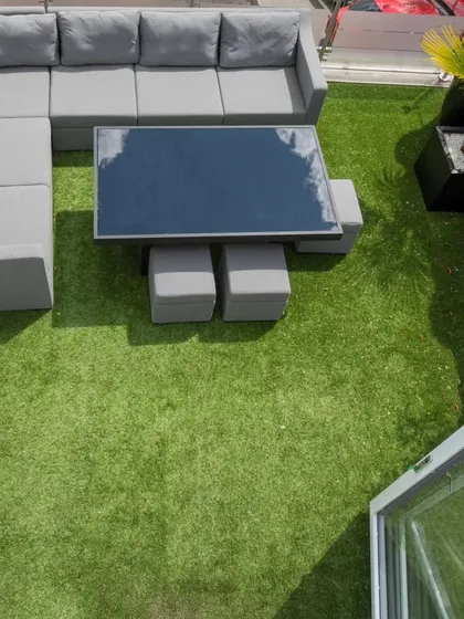 An overhead view of a completed terrace makeover. We covered the entire area with high-quality artificial turf, creating a soft, vibrant green space perfect for placing outdoor furniture and enjoying the open air.