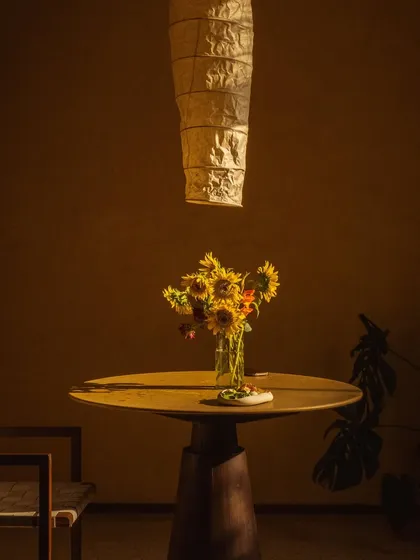 A vase of sunflowers catches the last rays of the day, bringing warmth and color to the minimalist interior.