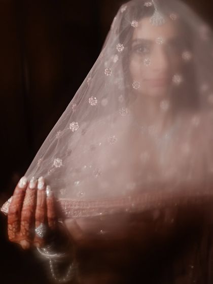 An artistic, soft-focus shot of the bride through her veil, creating a dreamy and ethereal portrait.