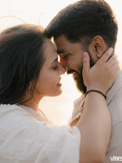An intimate close-up of a couple on the beach at sunset. They are touching foreheads and smiling, bathed in the warm, golden light, capturing a moment of pure connection and love during their golden hour couple photography session.
