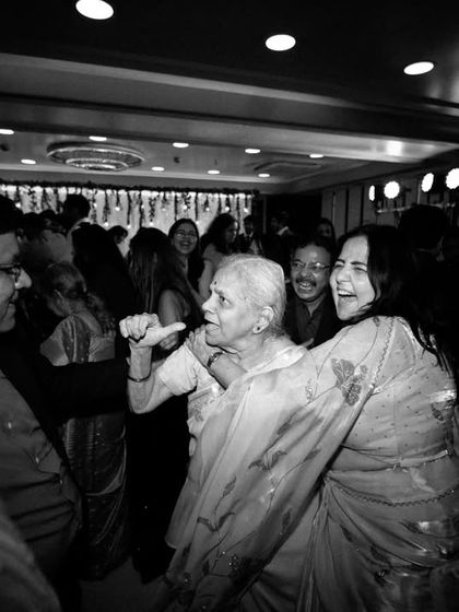 A high-energy black and white shot from the cocktail party dance floor, capturing the joy of the guests.
