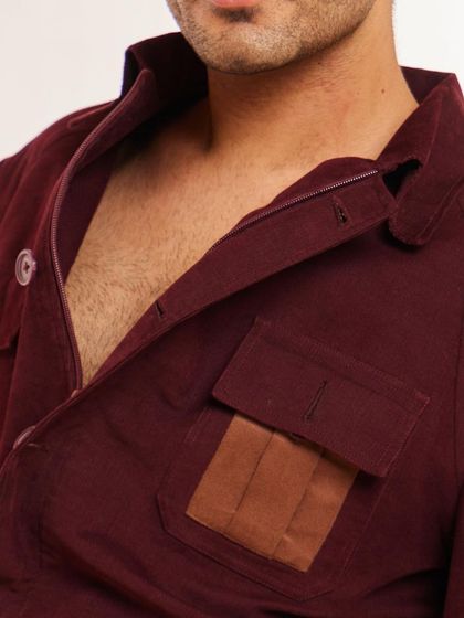 A close-up of the maroon shacket's collar and pocket area. This view shows the texture of the fabric and the precisely stitched leather patch, details that define our quality.