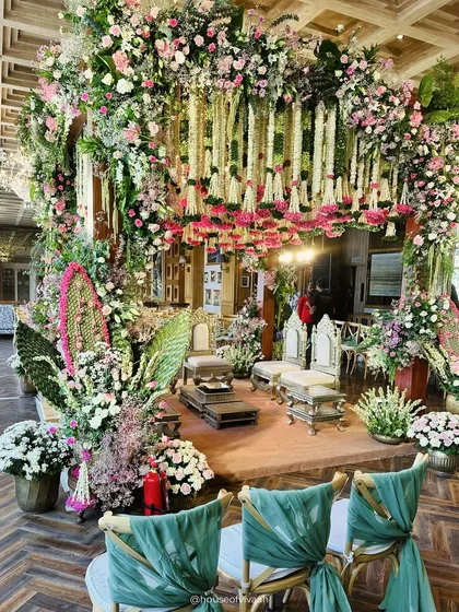A full view of the South Indian themed mandap, rich with pink and white florals, banana leaf accents, and elegant seating, demonstrating a perfect blend of tradition and luxury.