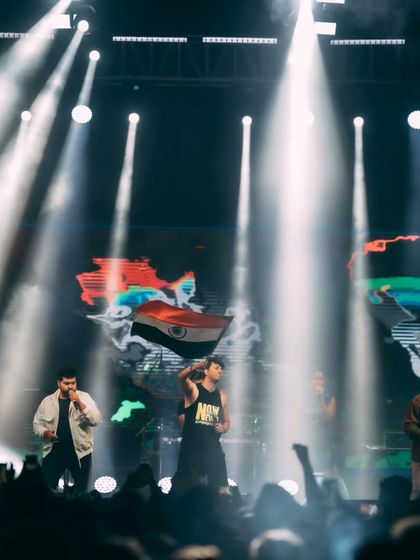 Salim-Sulaiman and their band on stage at the Indian School of Business (ISB), with the Indian flag displayed prominently.