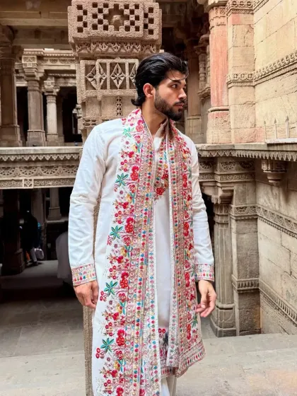 An off-white kurta paired with a stunning, multi-color embroidered stole. This shows how a simple accessory can elevate an entire outfit.