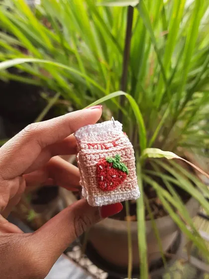Another shot of the strawberry milk amigurumi. It's a sweet and nostalgic design that makes a perfect accessory.