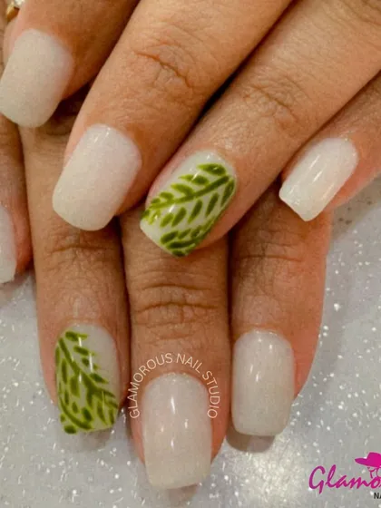 A fresh, nature-inspired look with milky white nails and accent nails featuring a detailed, hand-painted green leaf pattern.