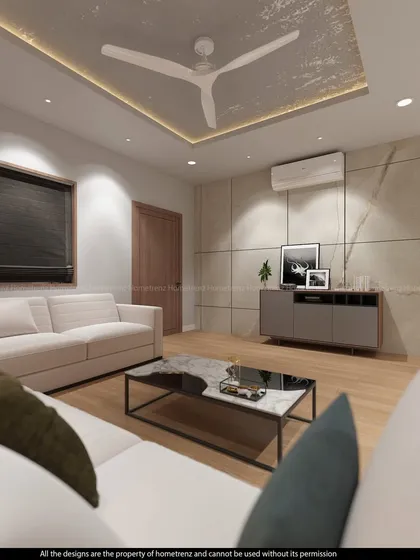 A cozy corner of a drawing room, featuring a comfortable white sofa and a simple, elegant entertainment console. The design emphasizes clean lines and a calm, neutral palette.