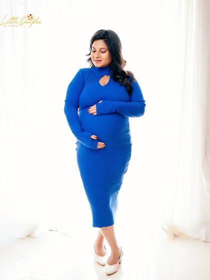 A simple and elegant portrait in a beautiful royal blue dress. The clean, bright background keeps the focus on the mom-to-be.