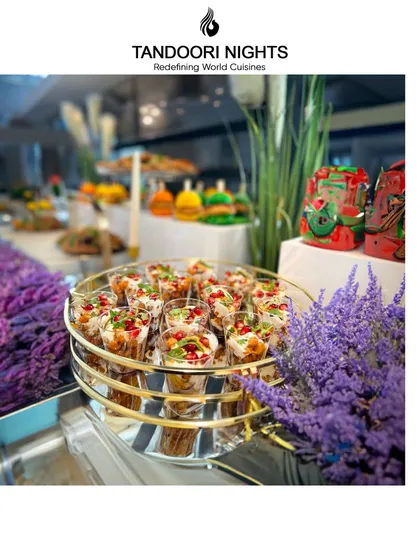 We don't just serve food; we serve an unforgettable experience. This buffet station is adorned with fresh lavender, complementing the colors of the individual chaat cups.