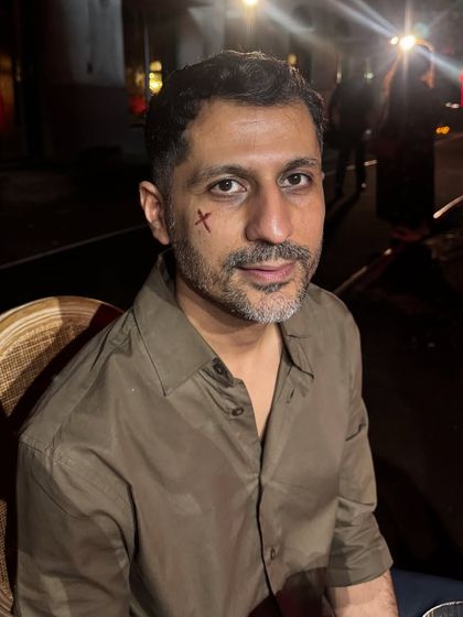 A minimal but effective cross-shaped wound painted on the cheek, showing that even small details can make a big impact.