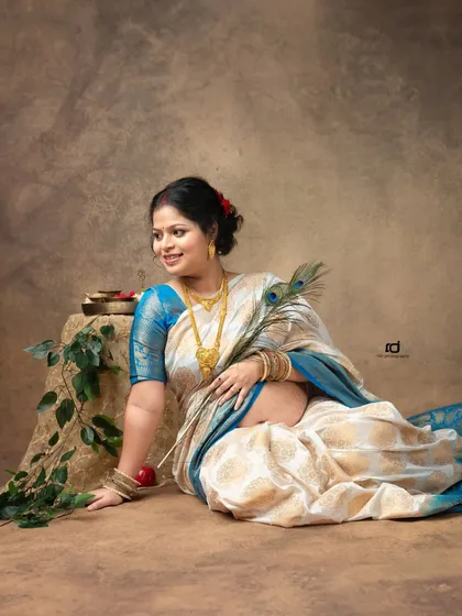 A serene portrait of a mom-to-be in a beautiful silk saree, holding a peacock feather. This pose is rich with cultural symbolism and timeless elegance.