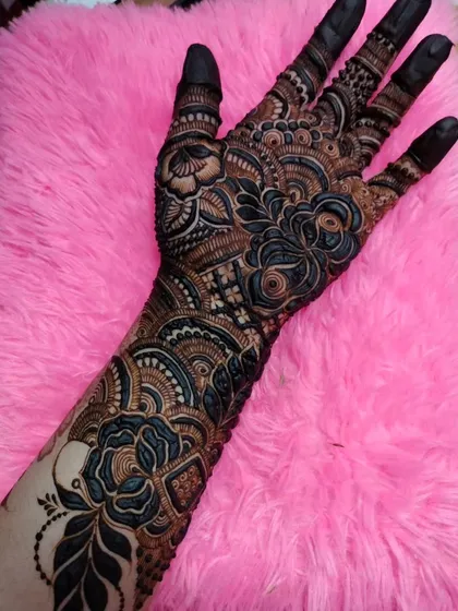 A full-sleeve design with bold, dark blue and black roses against a soft pink background, creating a dramatic and modern bridal look.
