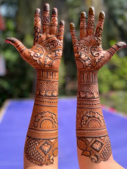 This full-arm design showcases a fusion of styles, with traditional motifs on the palm and more geometric, band-like patterns on the forearm for a contemporary feel.