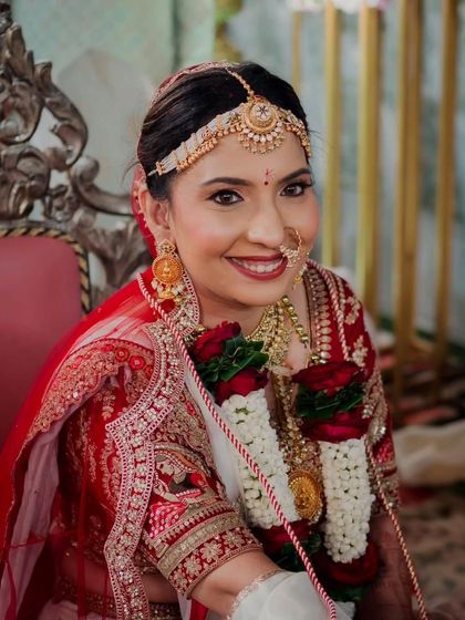 A close-up of this radiant bride. Her classic look features a red bindi, traditional matha patti, and a smile that shines, perfectly framed by her varmala.