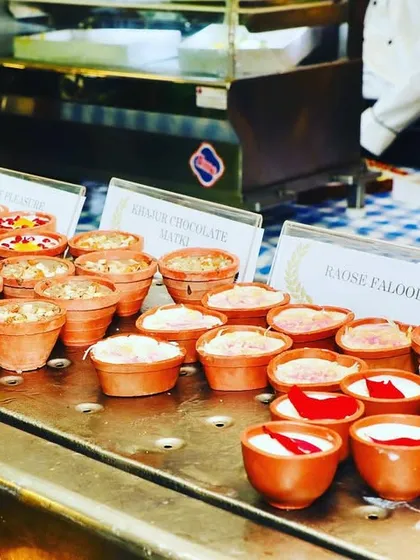 A variety of Indian desserts served in traditional clay pots (kulhads). This includes favorites like Rasmalai Falooda and Litchi Malai, presented in an earthy and authentic style.