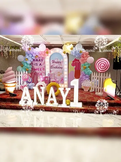 A wide view of the sweet-themed stage, featuring marquee letters, colorful backdrops, and fun props like a cool sunglasses-wearing ice cream cone.