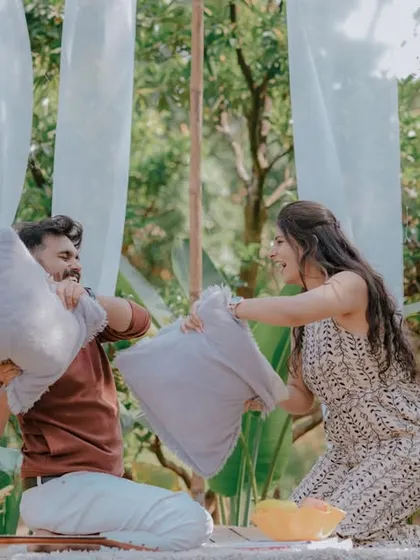 A playful pillow fight during a picnic-style pre-wedding shoot. This fun and energetic activity brings out genuine laughter and creates dynamic, memorable photos that show the couple's lighthearted connection.
