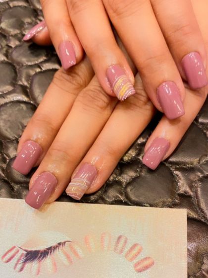 A sophisticated set of mauve-colored square nails. The ring fingers are accented with a subtle, textured pattern for a touch of uniqueness.