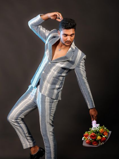 A dynamic and artistic pose in a stylish striped suit. Holding the bouquet adds a touch of softness and contrast to the sharp lines of the outfit.
