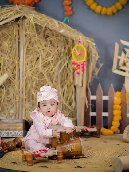 A playful shot of a baby trying to play the dhol, capturing a moment of fun and discovery during his first Lohri shoot.