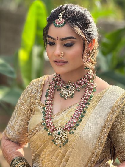 A close-up of the bride's makeup, highlighting the soft-cut crease eyeshadow and the intricate details of her temple jewelry.
