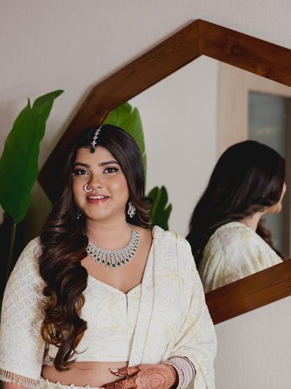 A modern portrait with a mirror reflection. Her makeup is clean and fresh, with a focus on luminous skin and bright eyes.