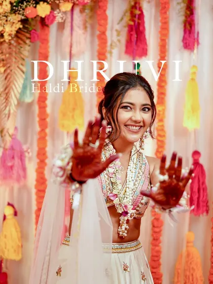 The most enthusiastic and happy Haldi bride. Her makeup is designed to be bright and joyful, matching her infectious energy and the colorful decor.