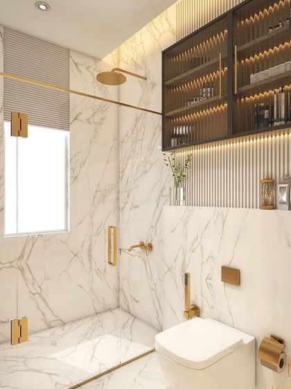 A bathroom that blends gold elements, sleek marble, and custom cabinetry. The fluted glass storage unit and warm ambient lighting create a perfect place to recoup after a long week.