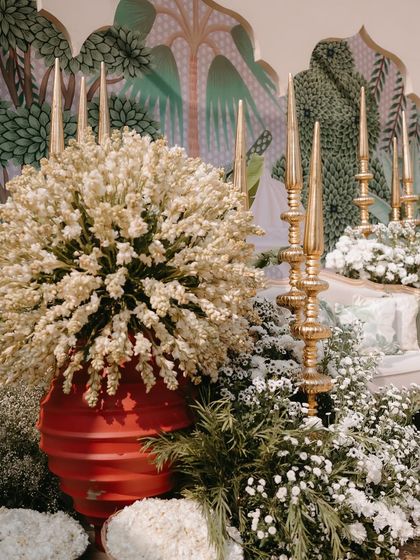A pop of color from a red vase contrasts beautifully with the abundance of white tuberoses, showing our thoughtful use of color to create visual interest.