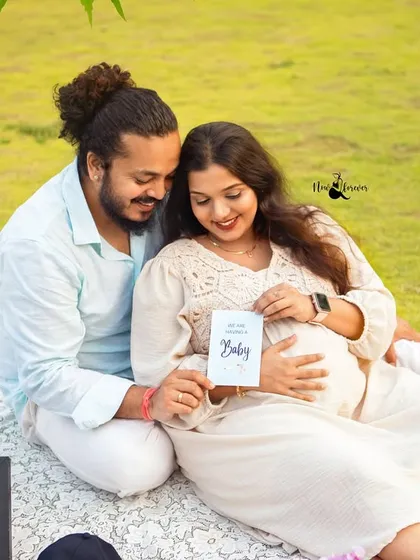 Announcing their joy to the world. This photo showcases the couple with a "Hello Baby" card and a custom letter board, making for a perfect pregnancy announcement picture.