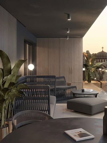 This balcony offers a timeless tropical retreat with a stunning city view. We used dark, woven furniture and large potted plants to create a sophisticated lounge atmosphere perfect for watching the sunset.