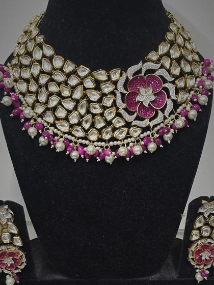 A beautiful real Kundan necklace set with a floral motif in pink and white stones. This piece is available for purchase.