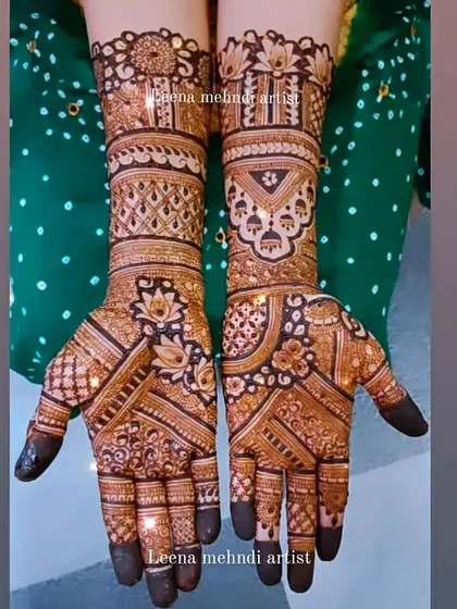 This is a classic siders mehndi, perfect for the bride's sister or close friends. It's a heavy, intricate design that complements the bridal look, featuring jhumka motifs and detailed patterns.