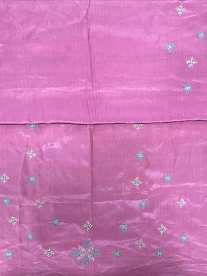 A lovely pink silk fabric with scattered Kasuti butis in silver and blue thread. This can be made into a saree, a kurta, or any apparel of your choice.