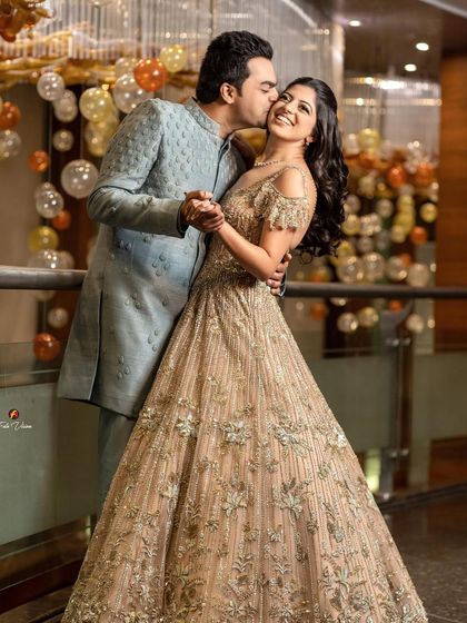 A playful and romantic dance pose, capturing the groom's kiss on the bride's cheek as she smiles, showcasing the fun and love of their sagan ceremony.