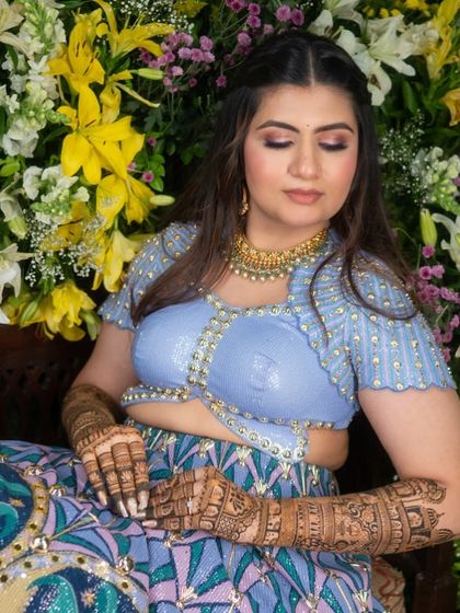 A serene moment with the bride, lost in thought, with her beautifully adorned hands resting on her lap.