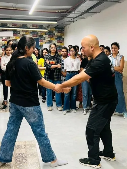 A female employee practices a wrist lock technique during a corporate self-defense workshop.