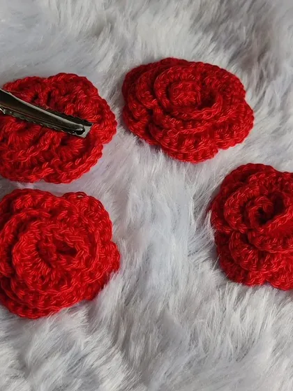 A set of four classic red rose hair clips, ready to be attached to clips or bands. Their timeless design makes them a versatile accessory.