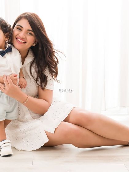 A relaxed and happy portrait of a mother and son sitting on the floor. Their genuine smiles and easy connection shine through.