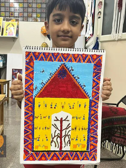 At just six years old, our students are already exploring rich cultural art forms. This young artist proudly holds his detailed Saura tribal art piece, a style from Odisha that teaches storytelling through intricate patterns and shapes.