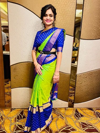 This client looks chic in a vibrant lime green and blue saree. I created a custom royal blue brocade blouse to match, adding a modern touch with a belt.