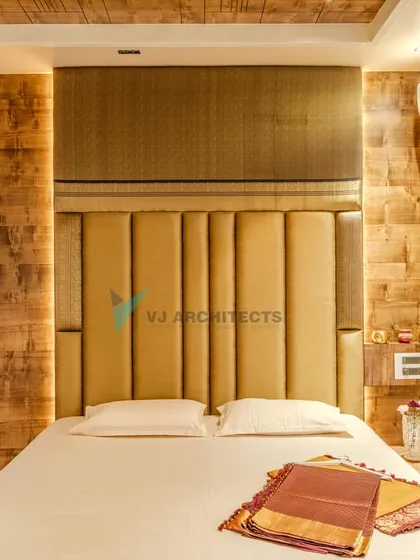 The bedroom design incorporates a mix of textures, from the upholstered headboard to the rough-hewn wood wall paneling. A small, built-in nightstand provides a convenient spot for essentials.