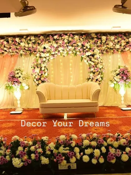 We create elegant stages for receptions and engagements. This classic design features a blush pink and white floral arch, soft drapery, and grand pillars to create a romantic and sophisticated atmosphere.