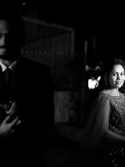 A creative black and white portrait of a Keralite couple. The dramatic lighting and composition highlight their connection while hinting at their shared journey.
