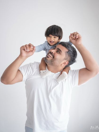 A fun shoulder-ride pose for a father and son, full of laughter and joy.