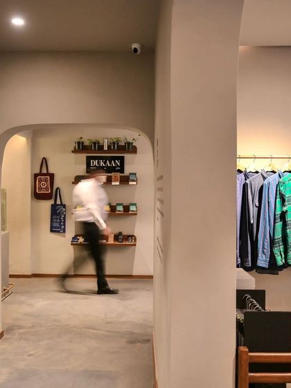 The entrance to the Bombay Shirt Company store, where arched doorways and a clean, minimalist aesthetic create a welcoming and modern retail environment.