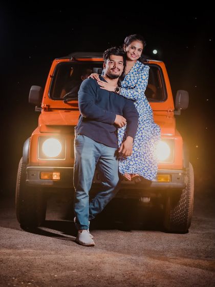 A cool and edgy night shoot with an orange jeep. The couple strikes a confident pose, showing off their fun and adventurous side in this unique pre-wedding photo.